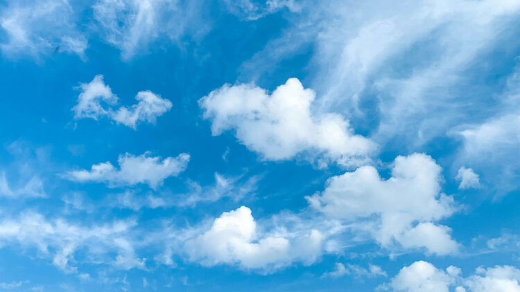 Blue sky with scattered white clouds.